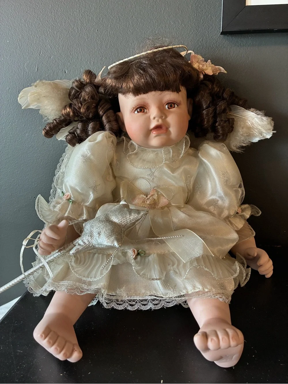 Vintage porcelain doll holding wand and wearing halo